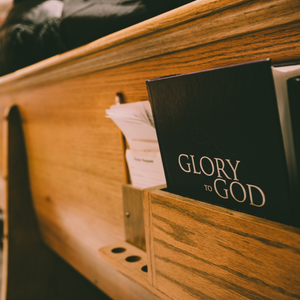 Back of church pew with hymnal titled Glory to God
