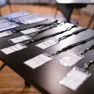 Name tags on lanyards laid out on a black table 