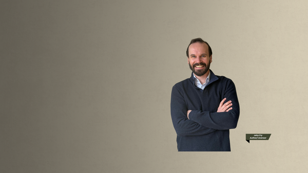 Man with a beard wearing a dark sweater on a beige background
